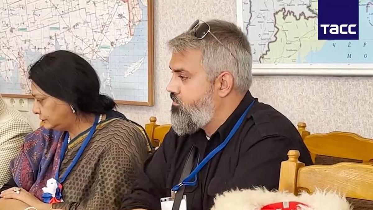 El politólogo prorruso Enrique Refoyo, sentado con Purnima Arnand, activista india pro Kremlin, el pasado 9 de septiembre, en una reunión de observadores de las elecciones rusas en territorios ocupados, según difundió un vídeo de la Agencia Tass.