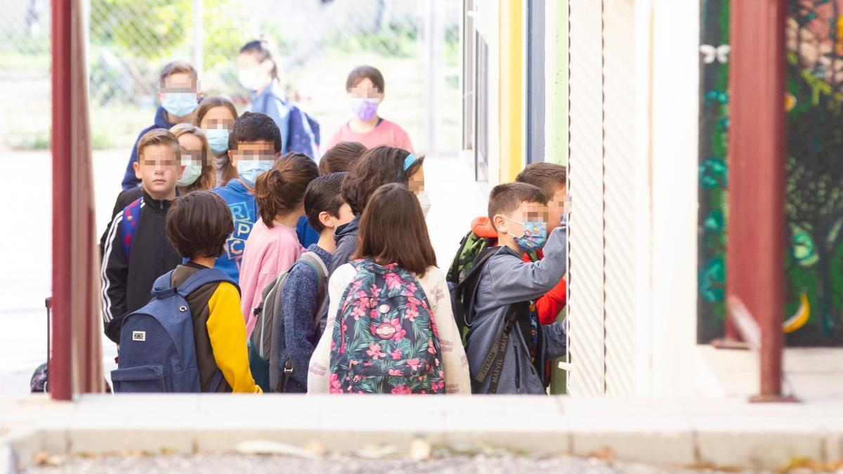 Niños acceden con y sin mascarillas a un colegio de Alicante