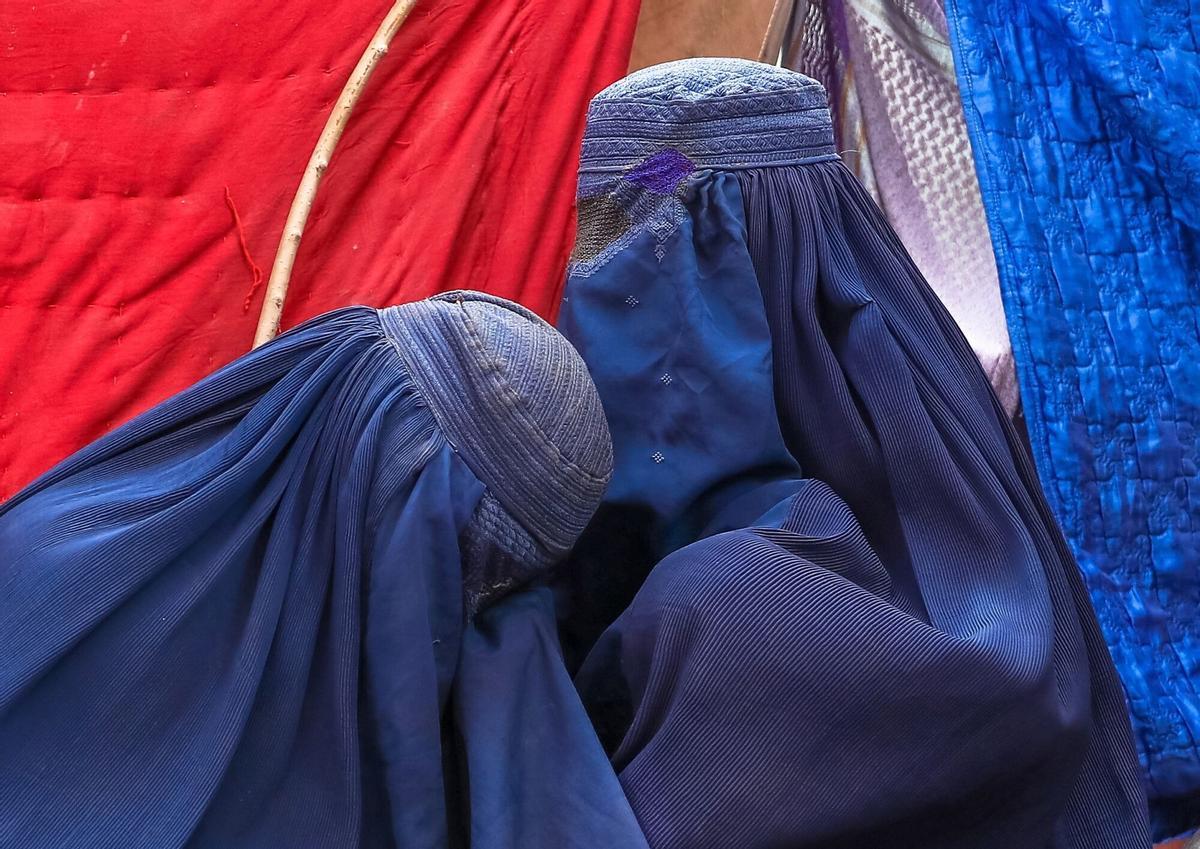 Dos mujeres en la ciudad de Mazar-i-Sharif, tomada por los talibanes, vestidas con un Burka. Kabul (Afghanistan), 14/08/2021.- Internally displaced families from northern provinces, who fled from their homes due to the fighting between Taliban and Afghan security forces, take shelter in a public park in Kabul, Afghanistan, 14 August (issued 15 August). The Taliban captured Mazar-i-Sharif, the country's fourth-largest city and the government's last major stronghold in the north on 14 August, as they tightened their grip on the country and closed in on Kabul. Most of the remote districts of the provinces have already fallen to the Taliban in the past three months. (Afganistán) EFE/EPA/HEDAYATULLAH AMID