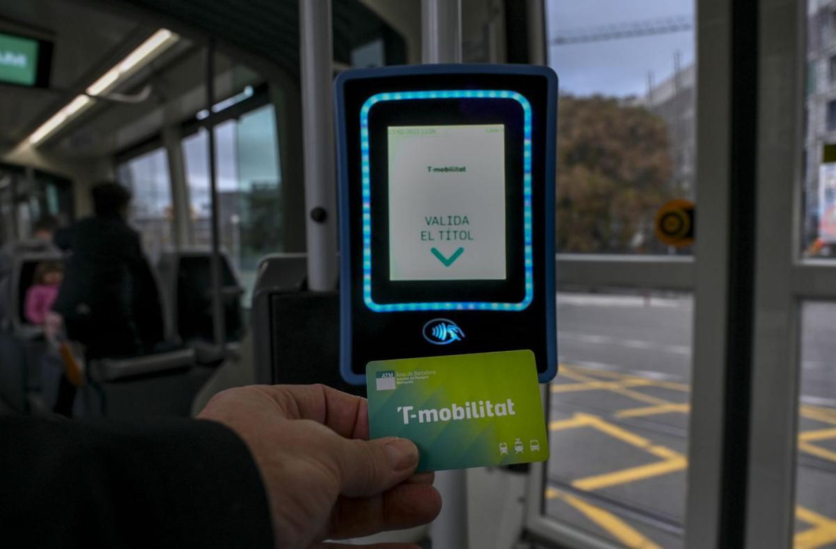 Un usuari valida amb la targeta T-mobilitat un viatge de bus a Barcelona. | JORDI COTRINA