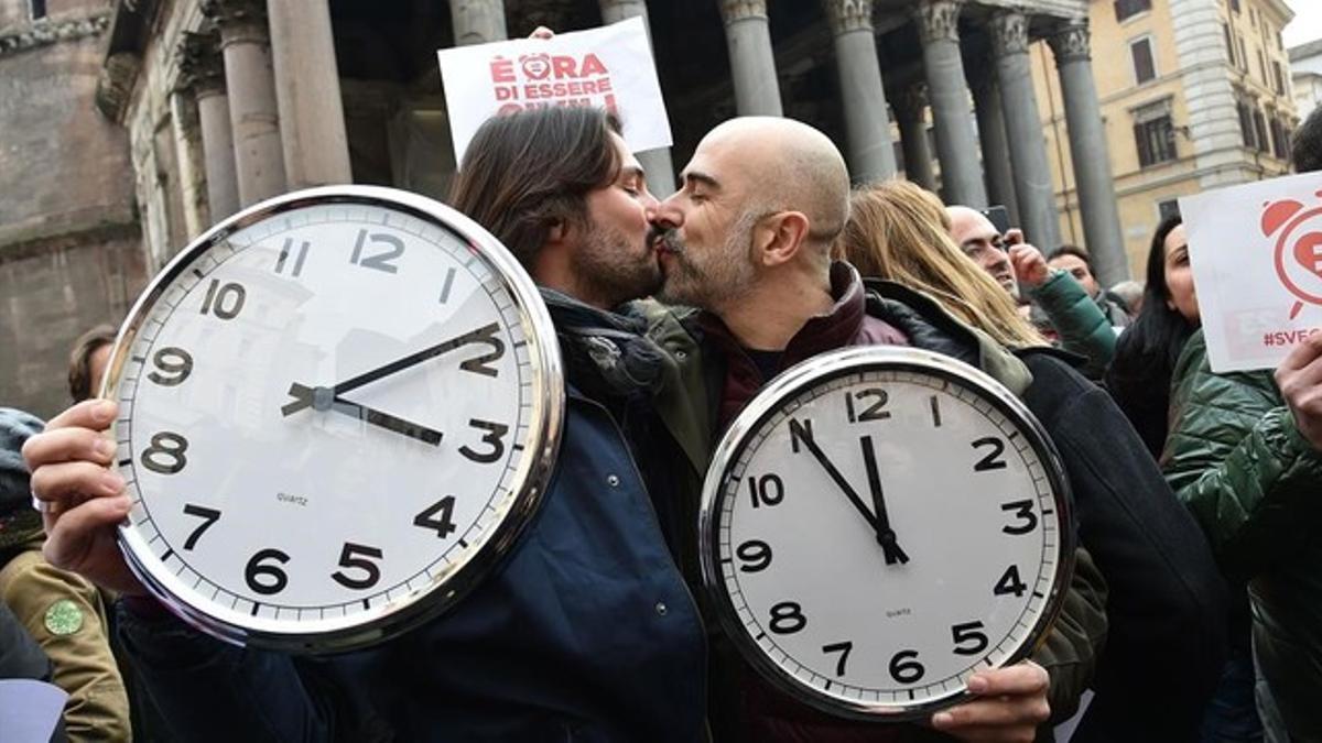 Una pareja con dos grandes relojes en la manifestación de Roma