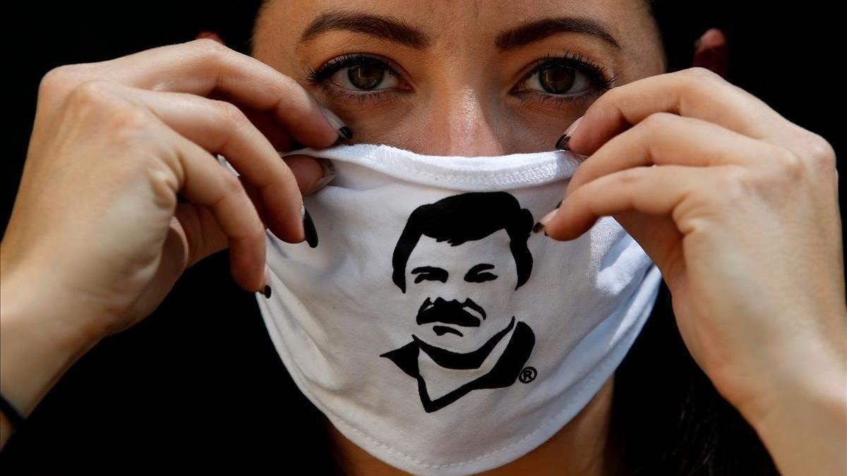Una empleada de la Fundación Alejandrina Guzmán luce una mascara de protección con la cara del famoso narco 'El Chapo' Guzmán.