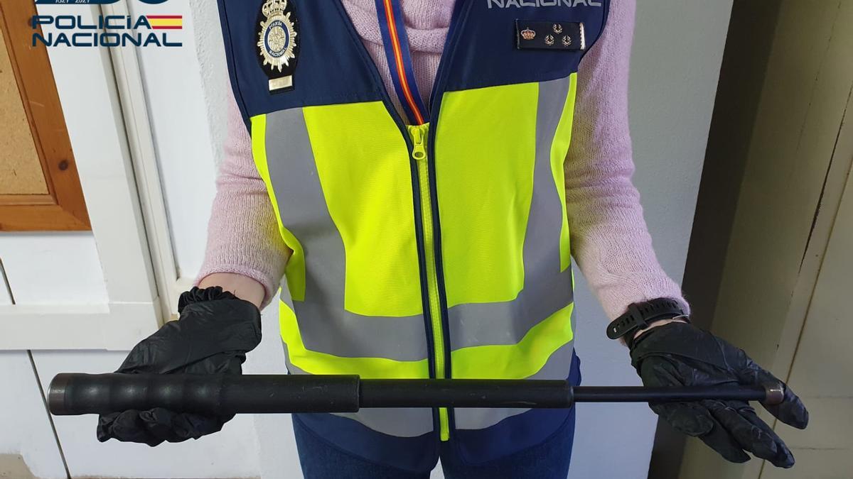 Un policía sostiene la porra extensible con la que agredieron a un hombre.