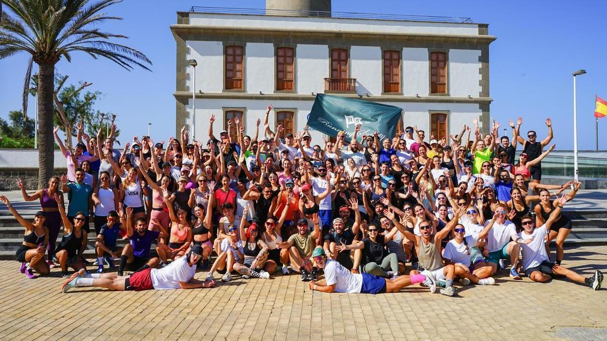 Miembros del Running Society posan a los pies del Faro de Maspalomas.