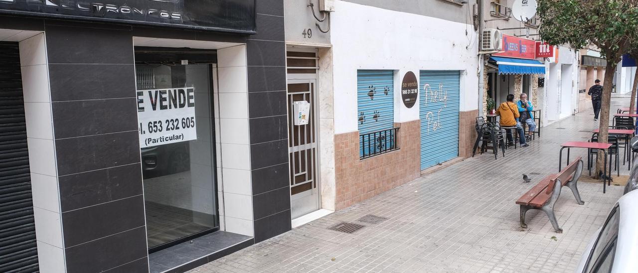 Dos bajos comerciales cerrados y con cartel de se vende en la avenida de Madrid de Petrer.