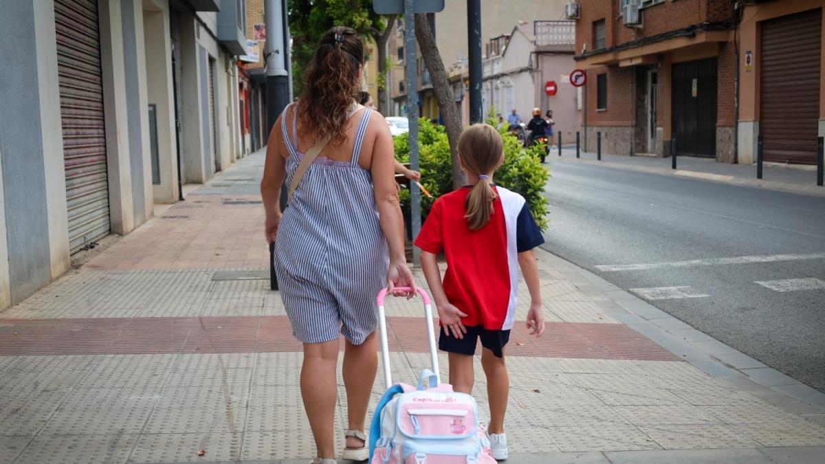 Una alumna acompañada por su madre, de camino al colegio.
