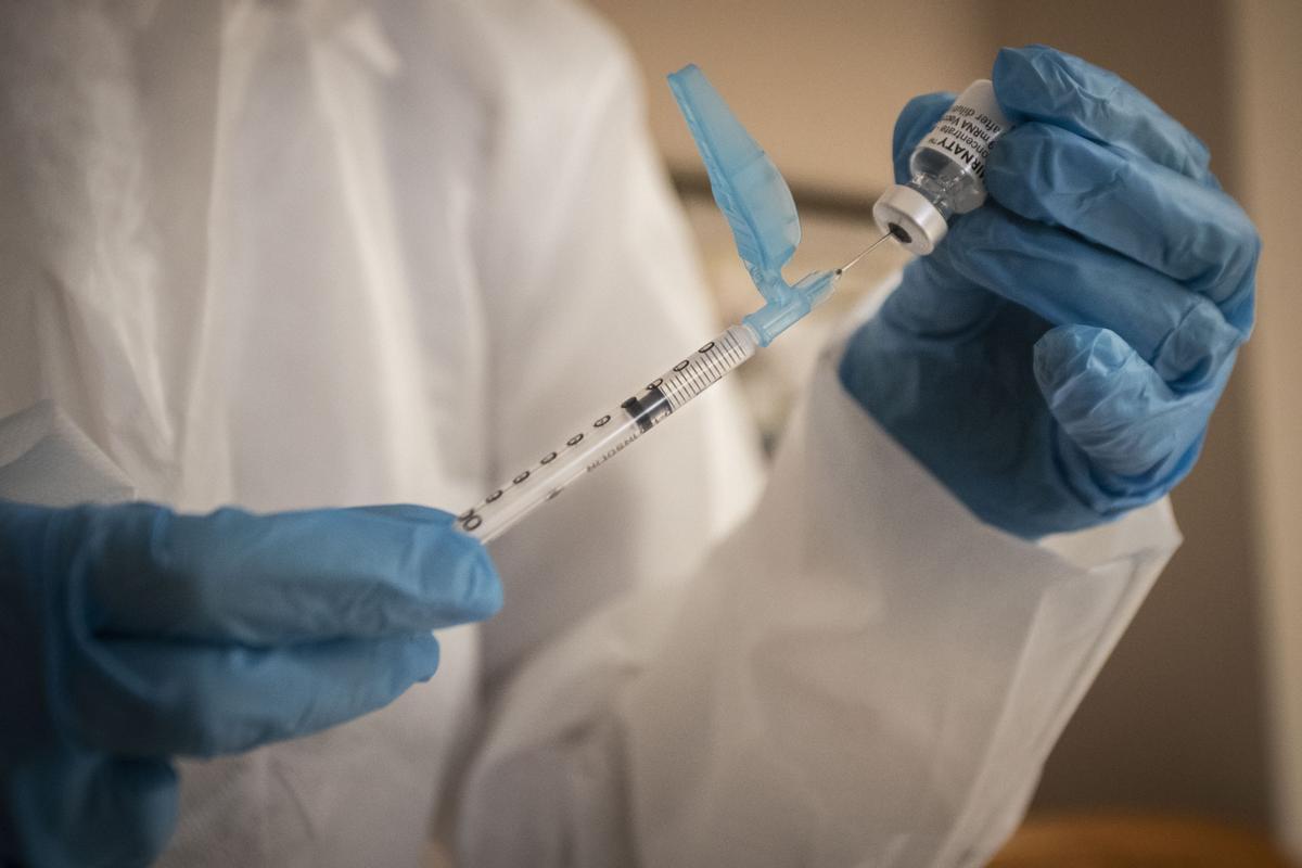Un sanitario prepara una vacuna contra el COVID.