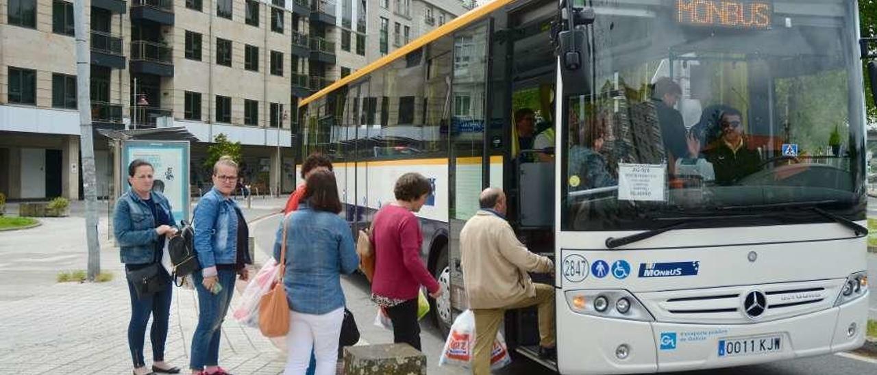 Un grupo de pasajeros sube al autobús en Vigo. // Rafa Vázquez