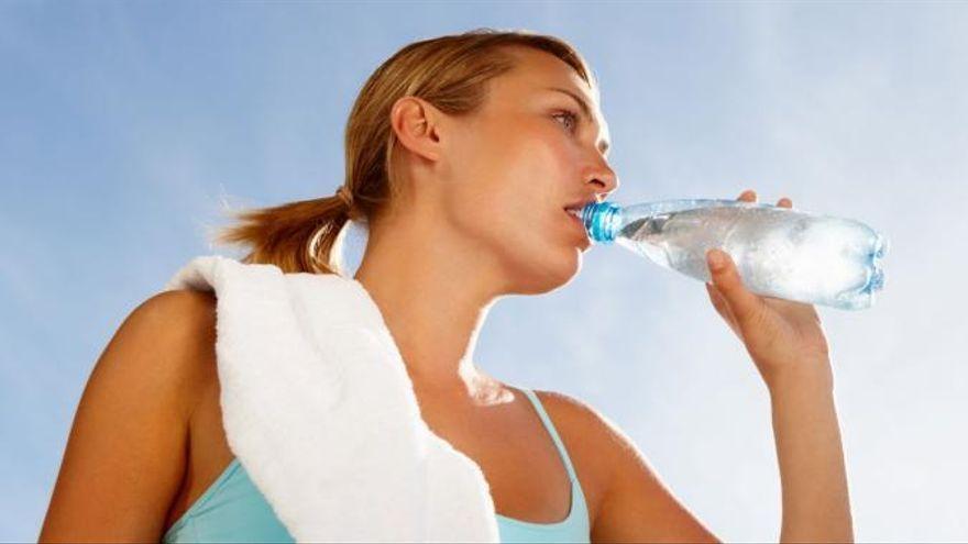 Una dona beu aigua per hidratar-se
