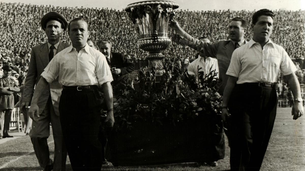 Fue necesaria la fuerza de cuatro hombres para exhibir el trofeo ante el público de Les Corts el día que el Barça se quedó en propiedad el Trofeo Martini &amp; Rossi. La entrega tuvo lugar el 10 de octubre de 1954, antes de un Barça-Atlético de Liga