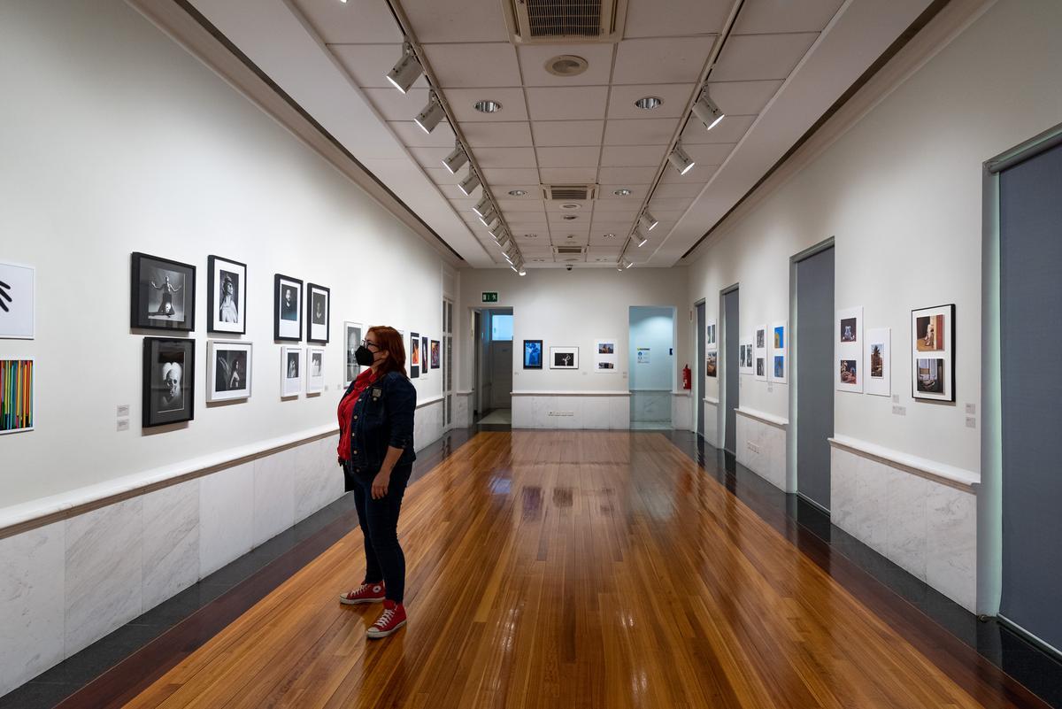 Una visitante observando las fotografías de la exposición 'Historia y actualidad de la fotografía en Canarias'