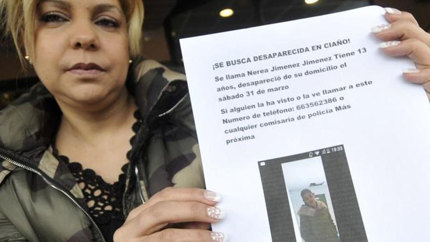 Estrella Jiménez muestra un cártel pidiendo ayuda para encontrar a su sobrina Nerea.