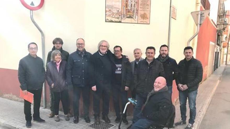 Los participantes en el acto posando junto al panel en un enclave histórico del casco antiguo.