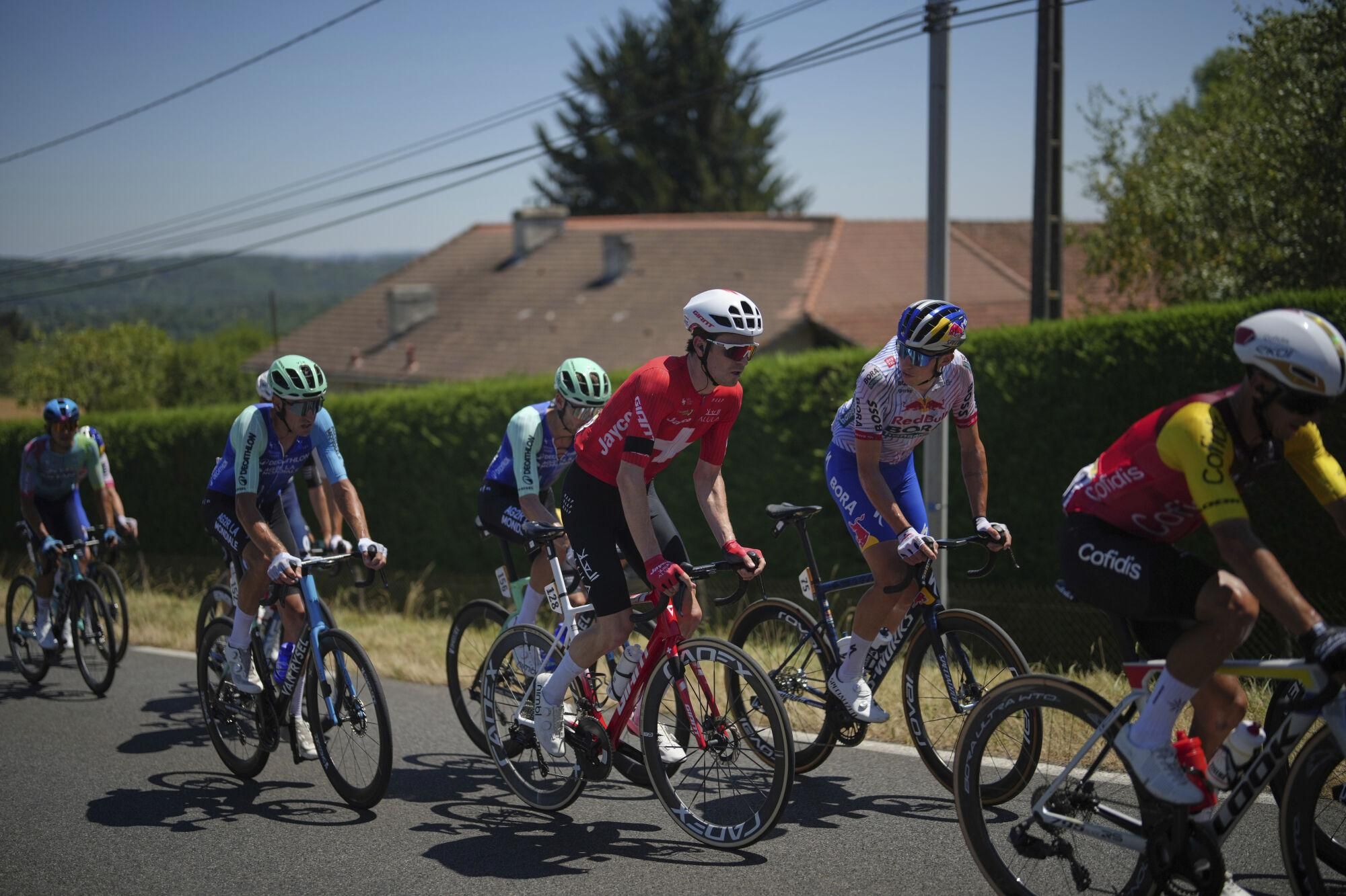 Switzerland's Mauro Schmid, in red jersey, and New Zealand's Laurence Pithie, second right, ride in the breakaway during the twelfth stage of the Tour de France cycling race over 180.6 kilometers (112.2 miles) with start in Auch and finish in Hautacam, France, Thursday, July 17, 2025. (AP Photo/Thibault Camus)