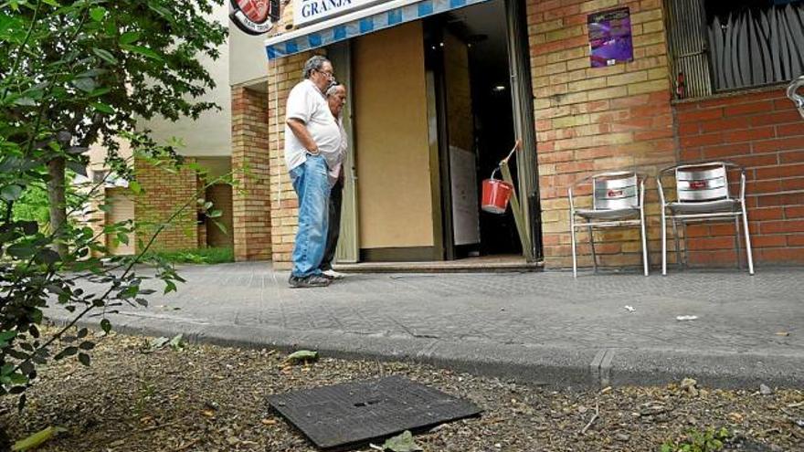 La tapa de claveguera amb què els lladres van trencar el vidre del bar, a l&#039;exterior