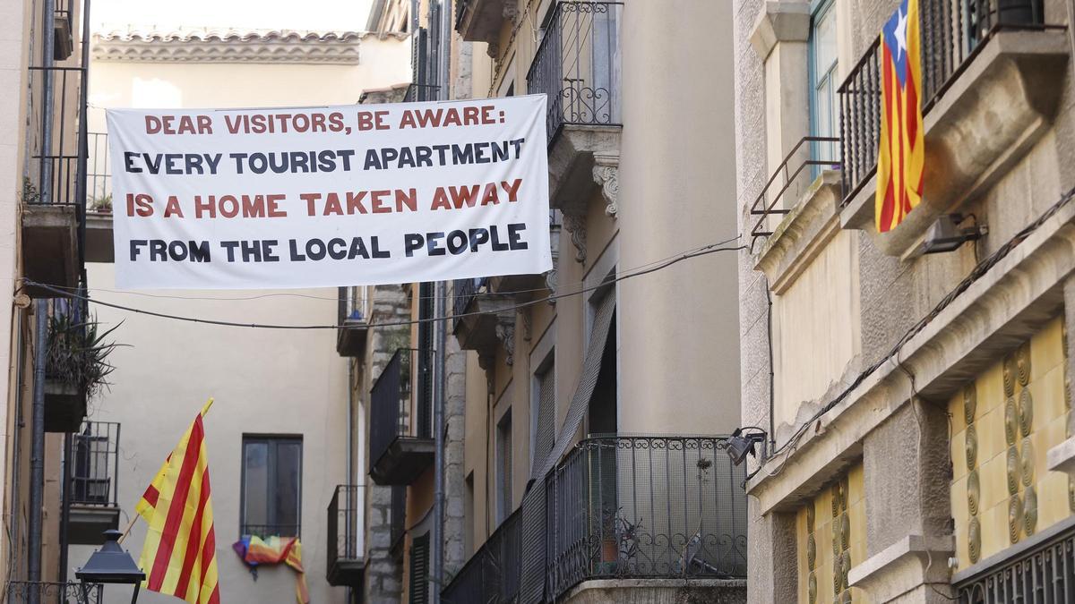 La plataforma Més Barri ha penjat diverses pancartes contra els pisos turístics a Girona.
