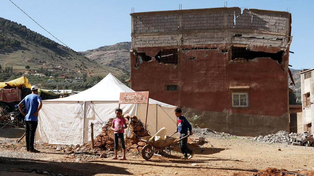 Hicham y sus hijos montan una nueva tienda de campaña en frente de la que fue su vivienda, ahora derrumbada.