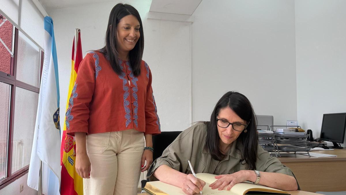 La rectora de la USC, Rosa Crujeiras, firmando en el Libro de Honor del Concello de Ribeira, ante la alcaldesa, María Sampedro.