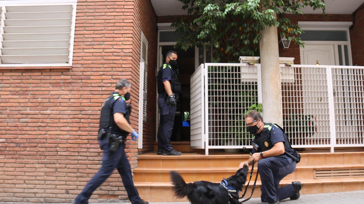 Policía Municipal y un perro de la unidad canina delante de un domicilio de la calle Sant Oleguer de Sabadell durante el registro de esta mañana