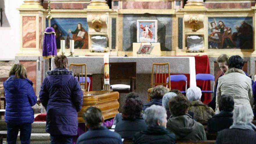 Vecinos de Muga ante el féretro del sacerdote José Luis Gutiérrez instalado ayer en la iglesia.