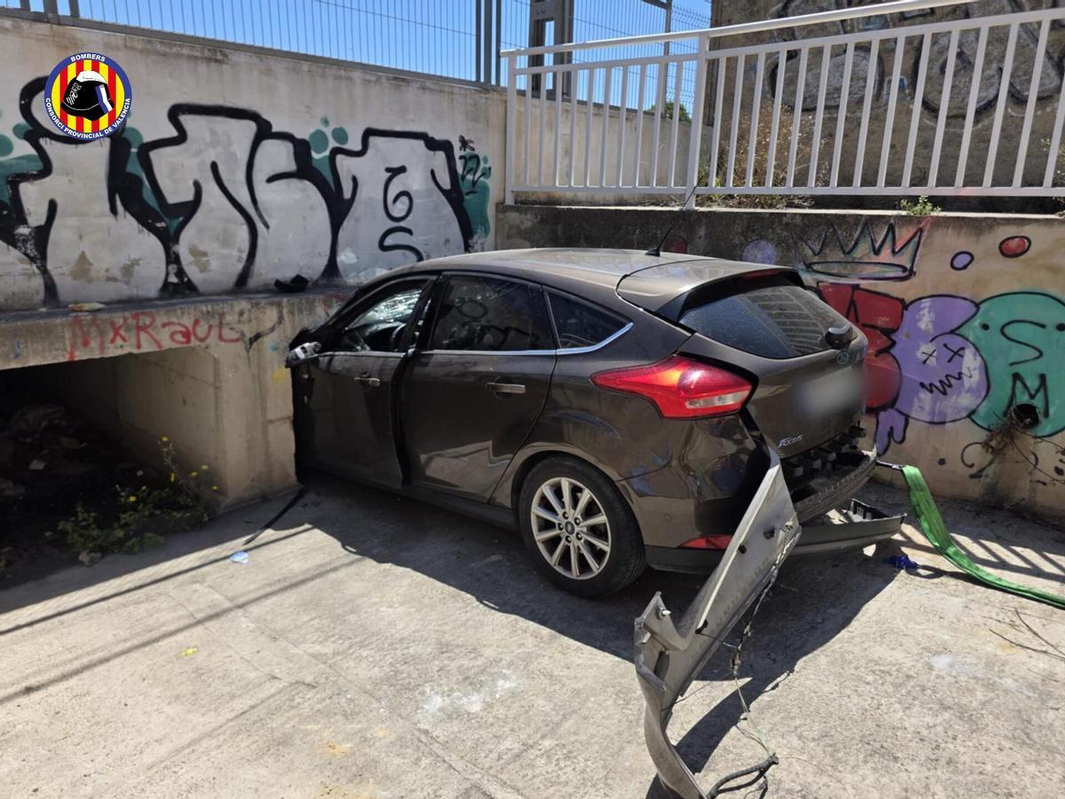 El coche empotrado contra el muro que protege las vías en Torrent.