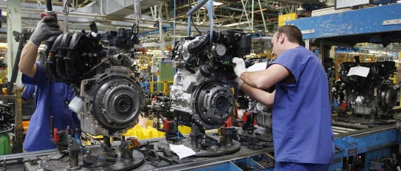 Dos operarios montan sendos motores en la planta de Ford en Almussafes.