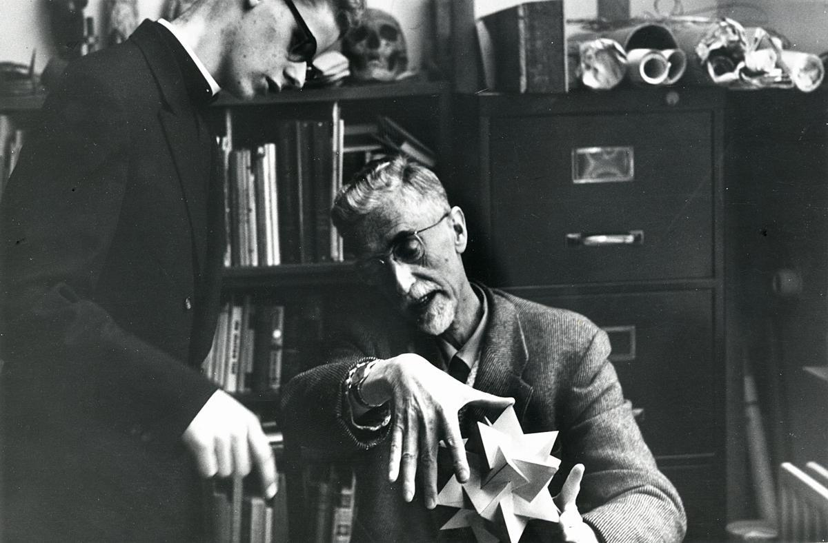 Escher explicando un sólido tridimensional a Chris Derks, en 1954.