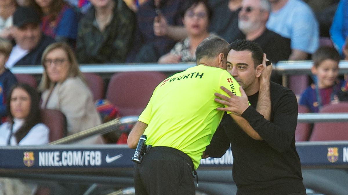 Mateu Lahoz se abraza a Xavi durante el derbi con el Espanyol en el Camp Nou.