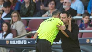 Mateu Lahoz se abraza a Xavi durante el derbi con el Espanyol en el Camp Nou.