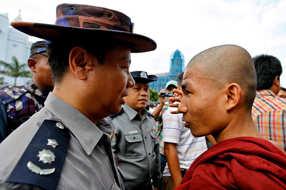 Un policia conversa amb un monjo budista, a Rangun (Birmània), on desenes de monjos es van congregar per protestar contra la violència entre membres de les comunitats musulmana i budista a l’estat d’Arakan, a l’oest del país.