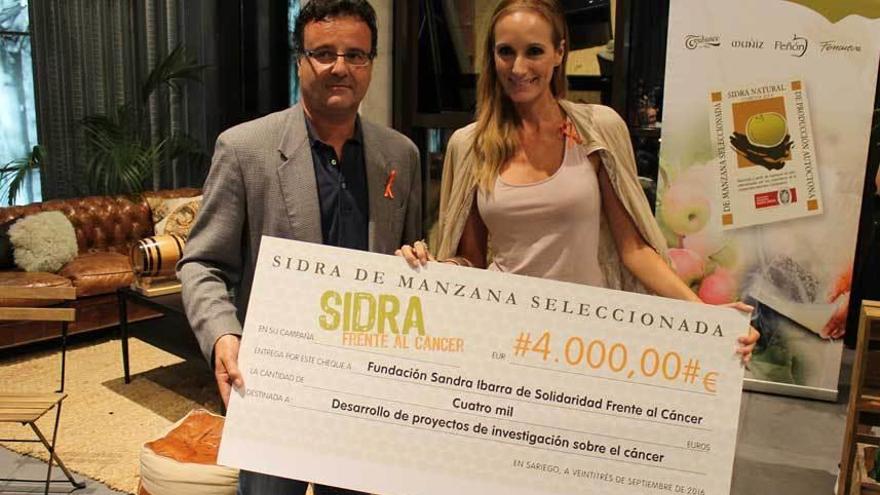 José Manuel Riestra entrega el cheque de 4.000 euros de la campaña &quot;Sidra frente al cáncer&quot; a Sandra Ibarra.