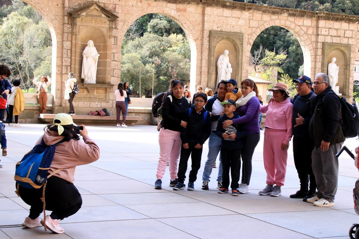 Un grup de persones es fa una fotografia al Monestir de Montserrat.