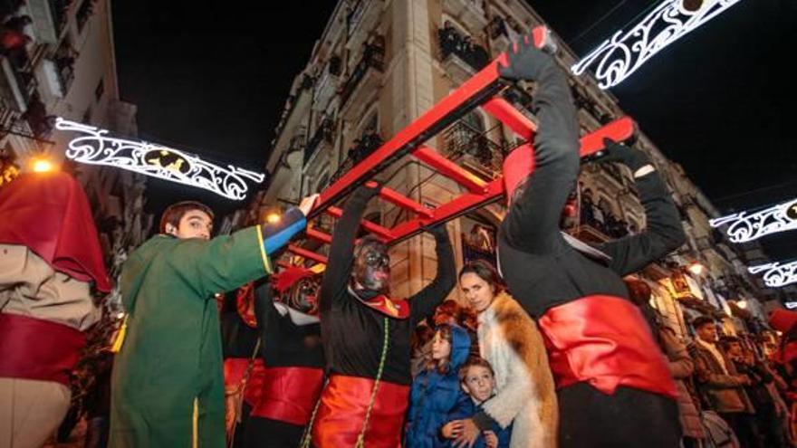 Un grupo de pajes portando una escalera para repartir los regalos.