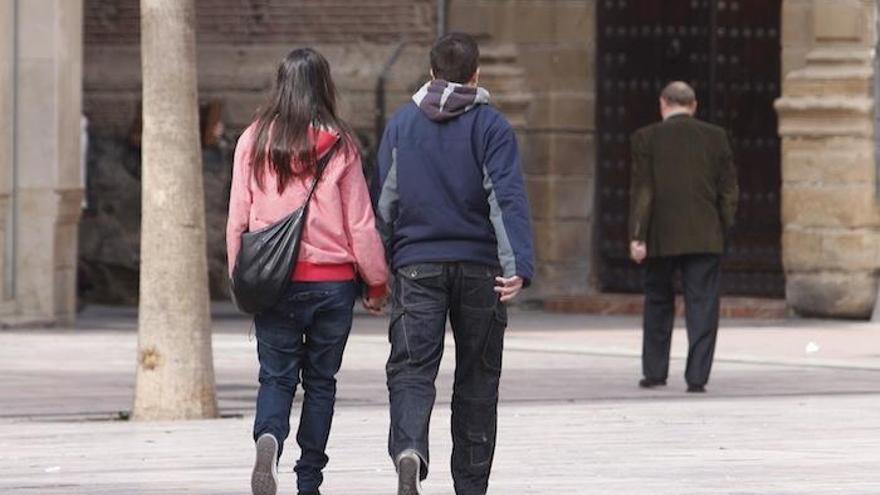 Una pareja pasea por una calle de la capital malagueña.