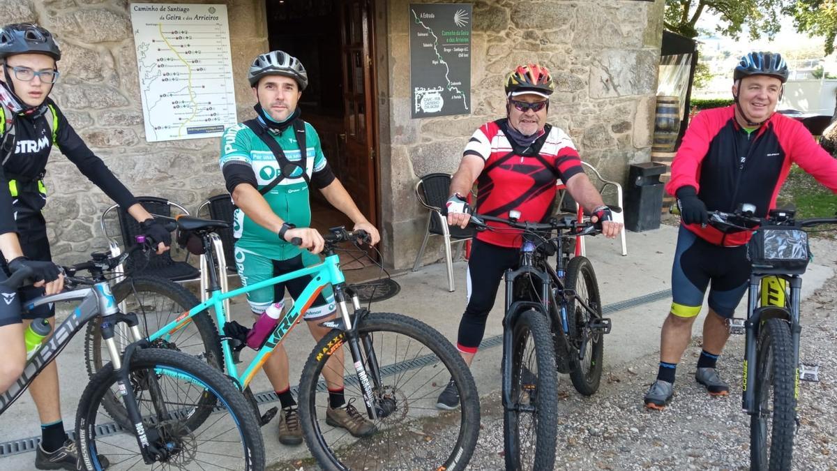 Los ciclistas Adrián, Fernando, Santas y Manolo de Vedra, ante el Café Pub Caminho da Geira de Codeseda.