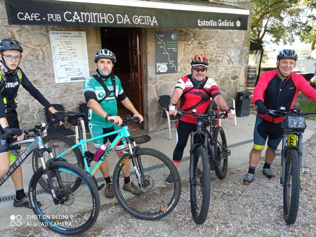 Los ciclistas Adrián, Fernando, Santas y Manolo de Vedra, ante el Café Pub Caminho da Geira de Codeseda.