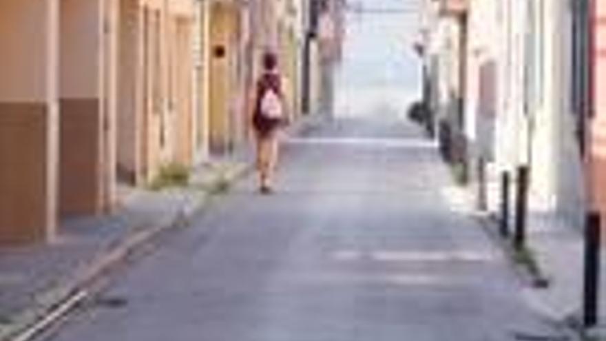 Una persona camina pel carrer Muntanya, evitant la vorera estreta i plena d&#039;entrebancs.