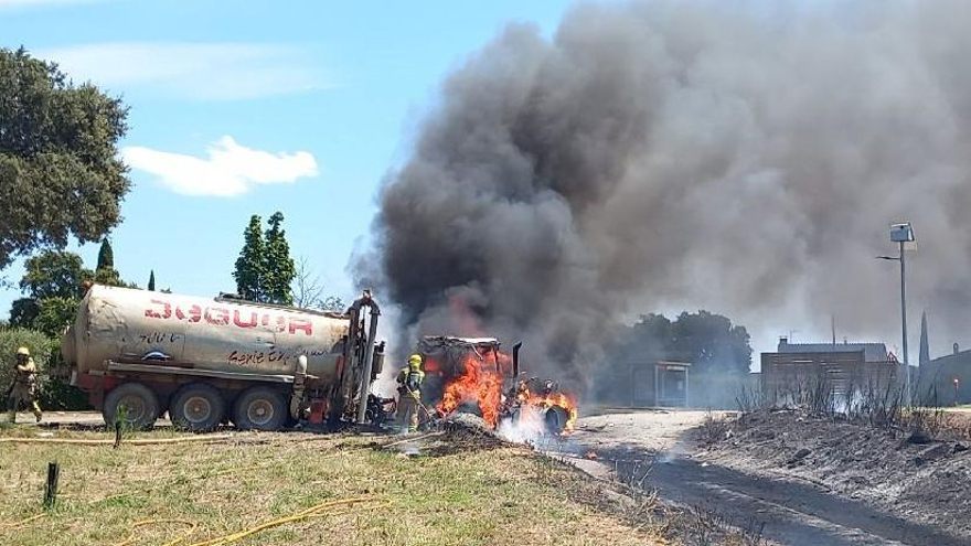 Els Bombers treballant en l'incendi del tractor que va agafar els marges de la carretera a Garrigàs.