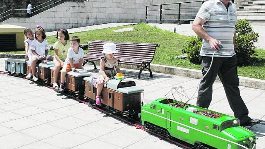 Manuel Cañamero lleva a varios niños en sus miniaturas en el parque de Les Conserveres.