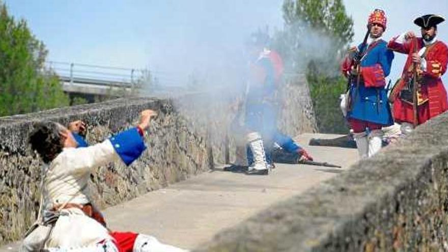 Recreació d&#039;una batalla al pont vell de Castellbell entre els miquelets, al fons, i tropes borbòniques