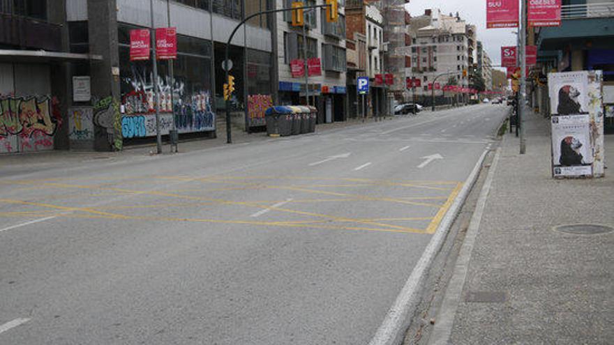 Un carrer de Barcelona buit amb dos vehicles al fons