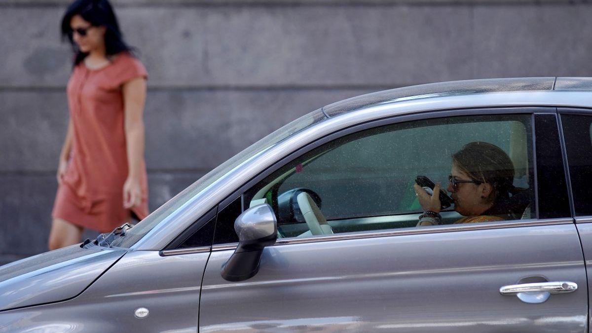 Una dona parla pel mòbil a l&#039;interior del seu cotxe