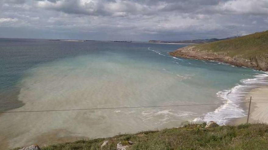 El mar arrastra parte de la arena depositada para anchear la playa de Combouzas.