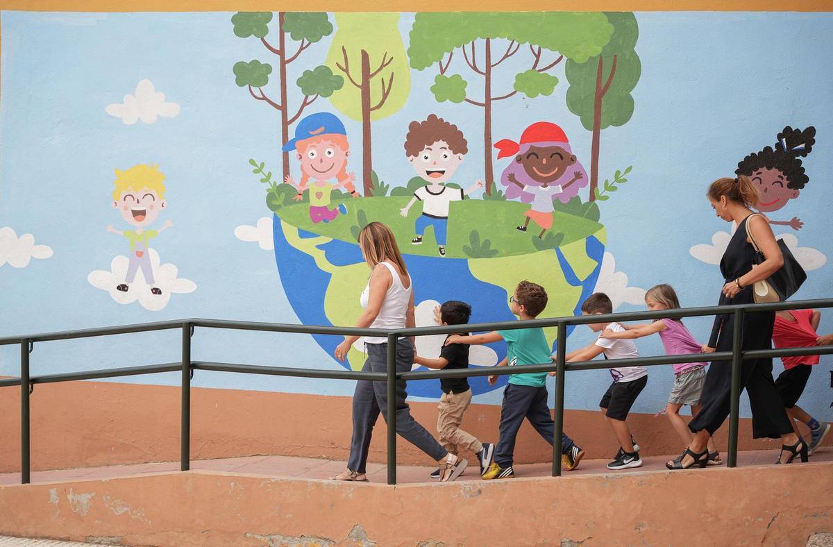 Unos niños se dirigen a un colegio para entrar a clase.