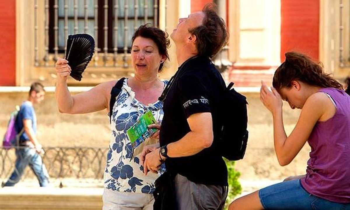 Una parella de turistes es refresca amb un ventall al centre de Sevilla. L’Agència Espanyola de Meteorologia ha decretat l’alerta vermella en algunes localitats d’Andalusia a causa de la intensa calor.