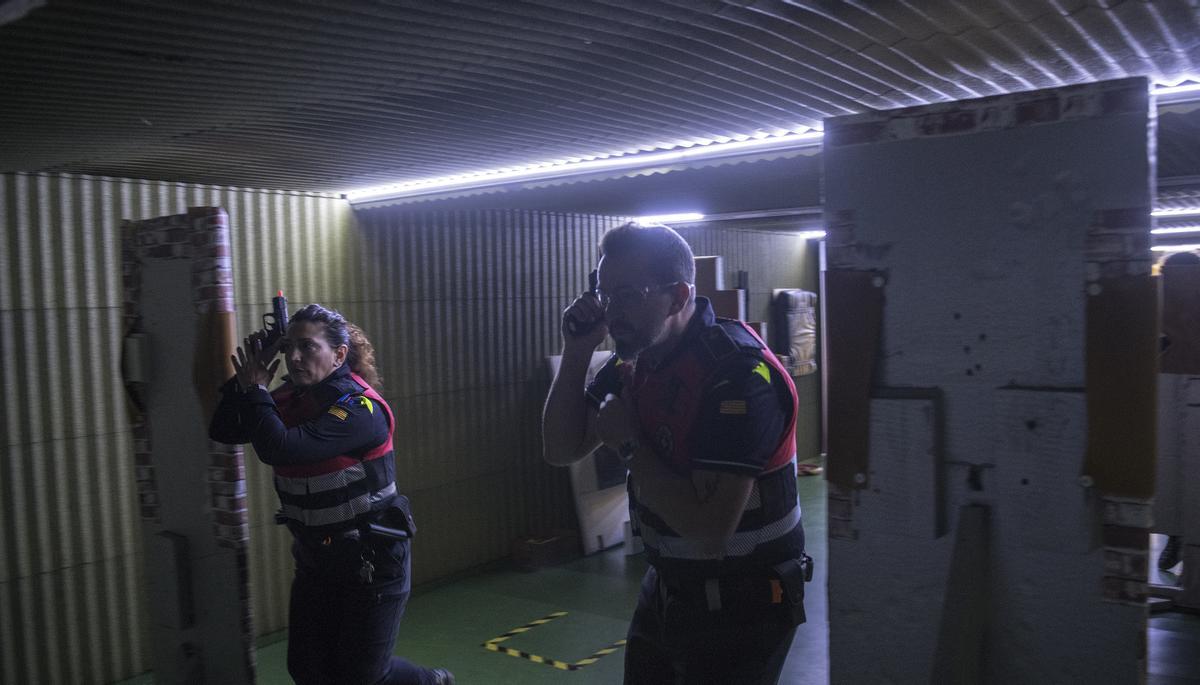 Los agentes avanzan por la galería, mientras se desarrolla la acción en el video reproducido en la pantalla del fondo de la sala