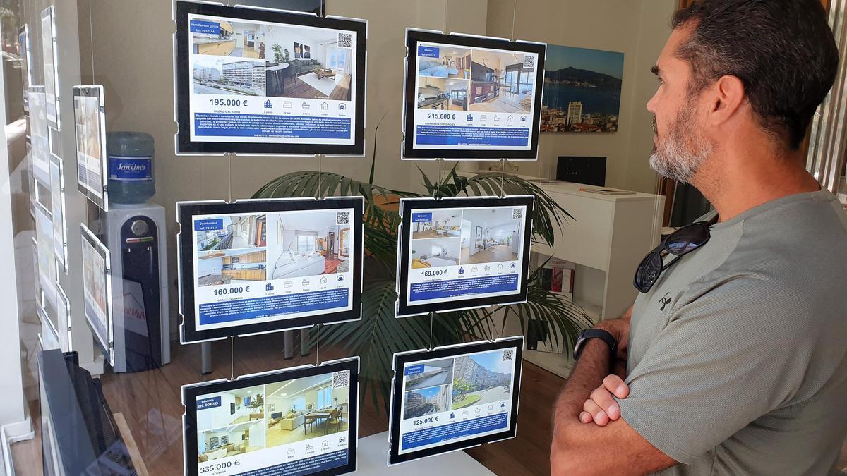 Un hombre ve anuncios de pisos en una inmobiliaria de Vigo.