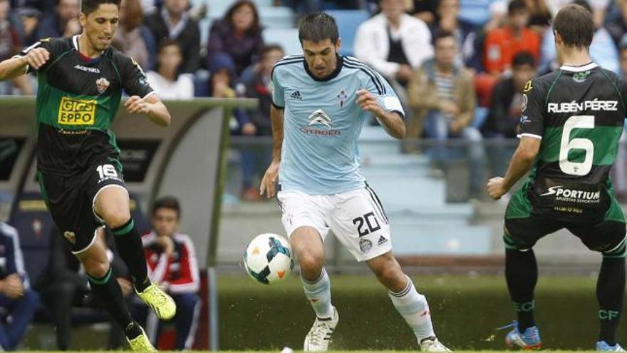 Toni conduce el balón entre dos rivales durante el compromiso disputado contra el Elche en Balaídos en septiembre pasado. // Ricardo Grobas