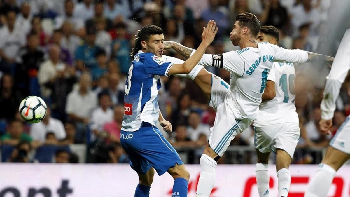 Sergio Ramos pugna por un balón ante Aaron Martín.