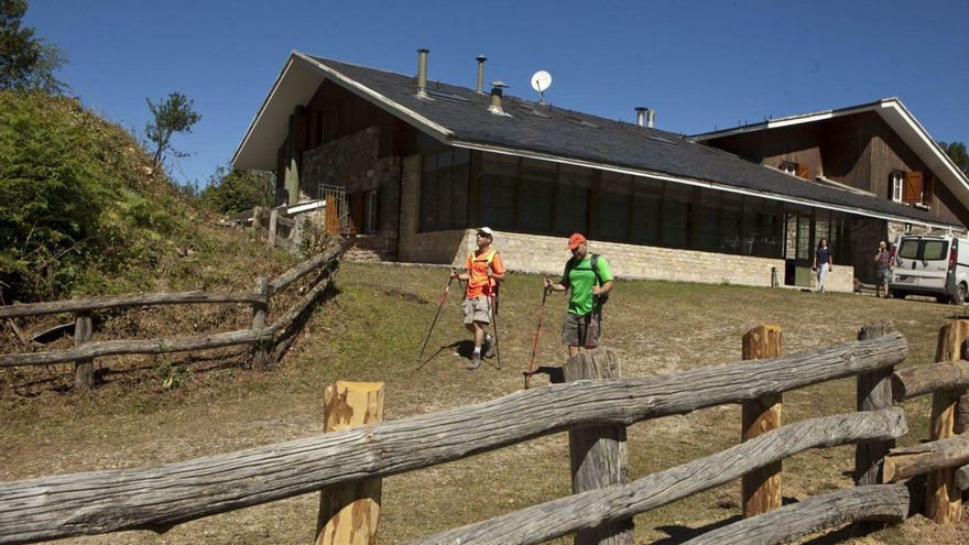 Senderistas en Brañagallones, en el Parque Natural de Redes, con el refugio al fondo. | FERNANDO RODRÍGUEZ